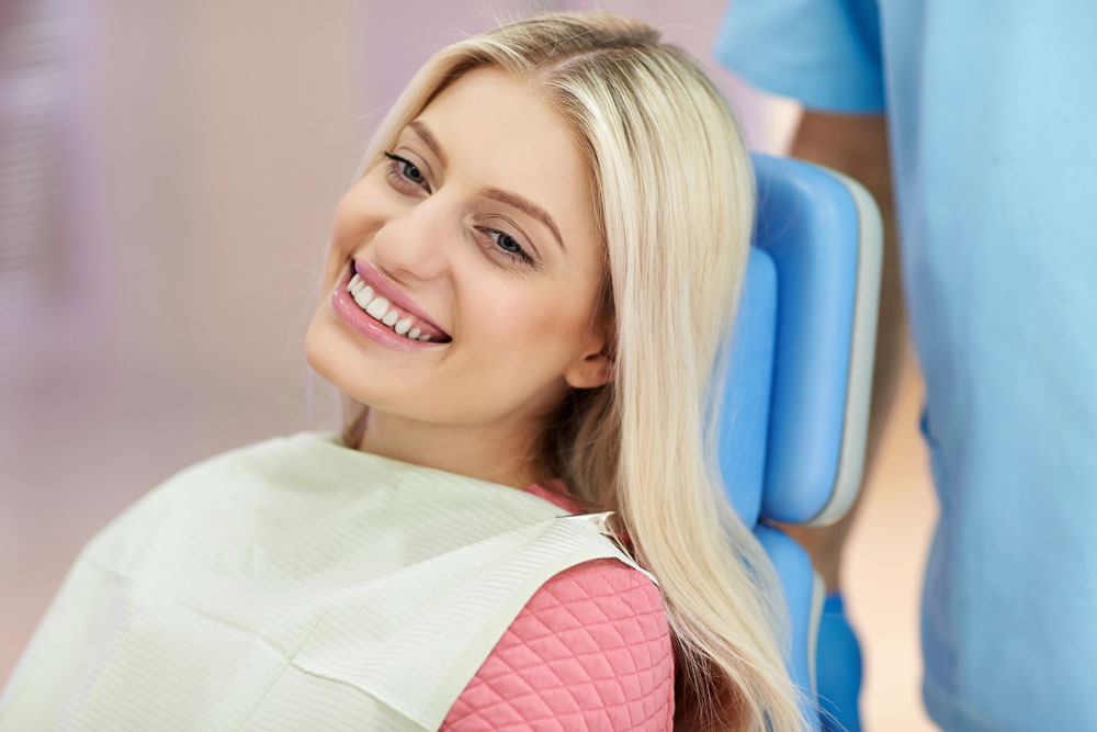 Smiling young woman seated at orthodontics appointment