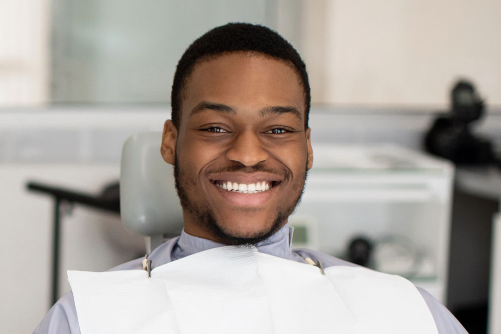 Smiling young man seated at orthodontics appointment