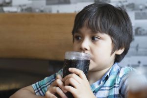 Young boy sipping a soft drink